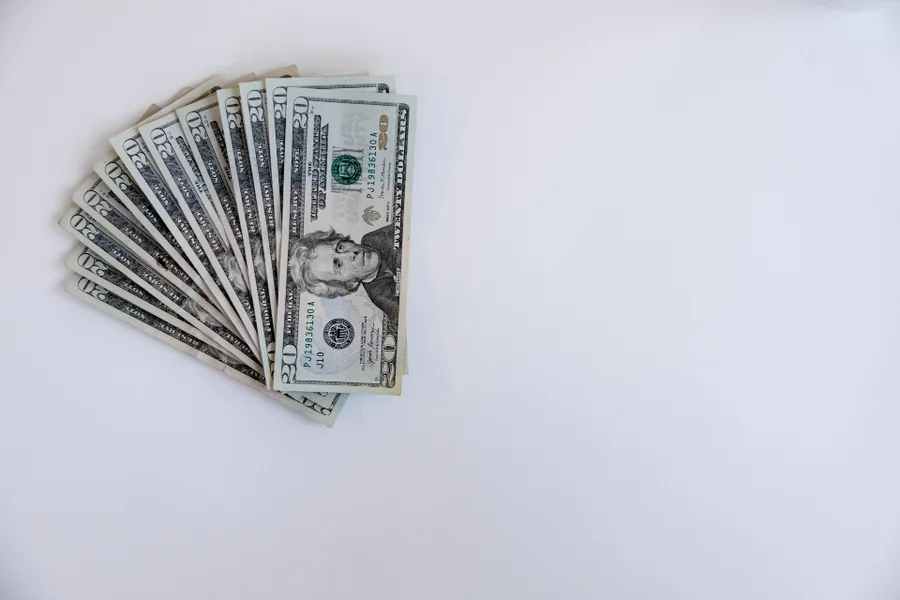 A fan of US dollar banknotes on a white surface